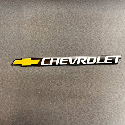 Gold Chevy Bowtie tailgate emblem with silver Chevrolet lettering for 1999-2006 Chevrolet trucks and SUVs.