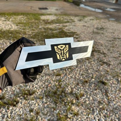 Chevrolet Bowtie automotive emblem with gold Autobot symbol and silver border