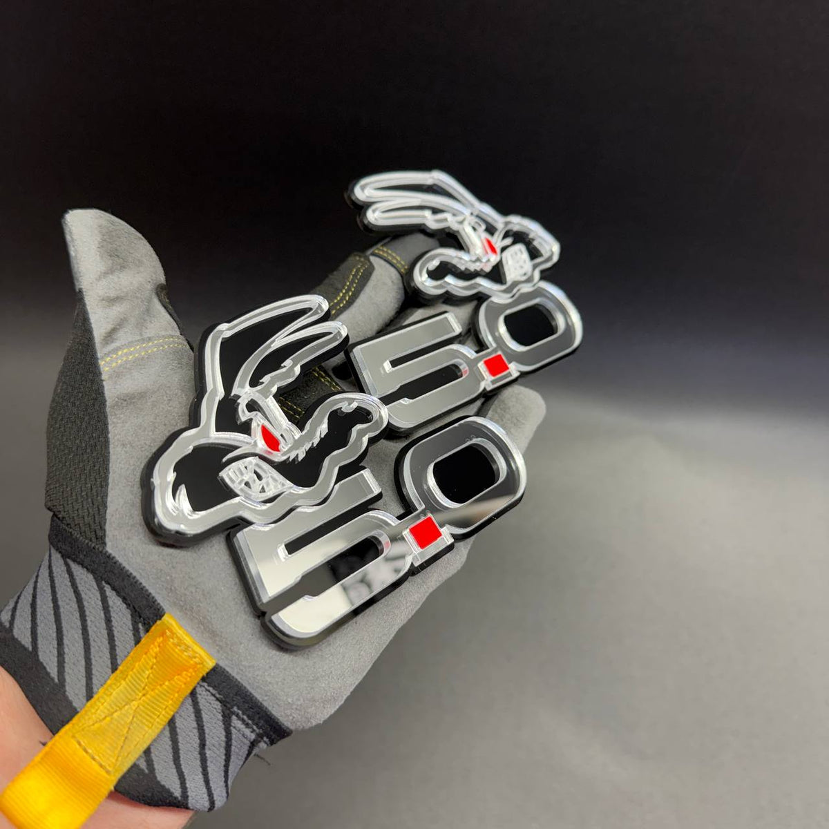 . Laser cut Coyote 5.0 car badge in mirror silver and glossy black with red accents for custom fender and tailgate styling.