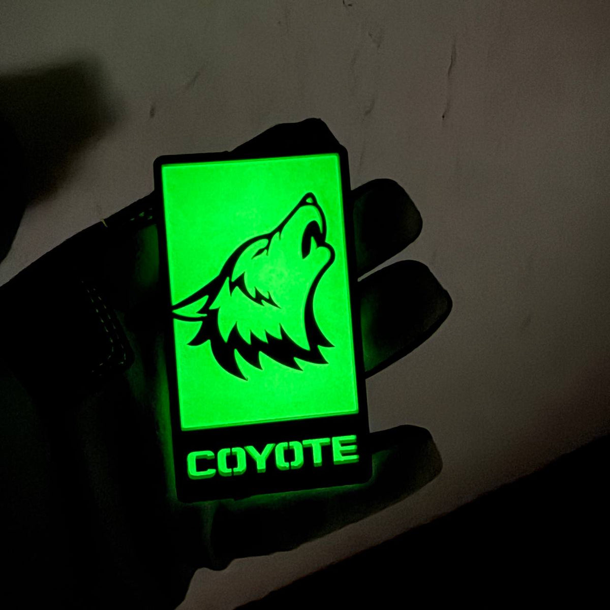 Coyote neon green night glow automotive badge with black wolf silhouette design