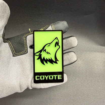 Coyote glow in dark car badge with bright green illumination and black wolf design