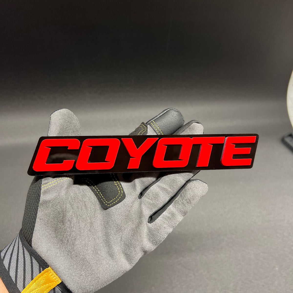 COYOTE RACING car emblem with red lettering on black base