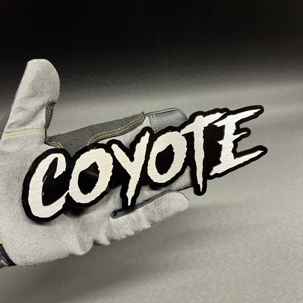 Custom text COYOTE car badge with red lettering and glossy black base