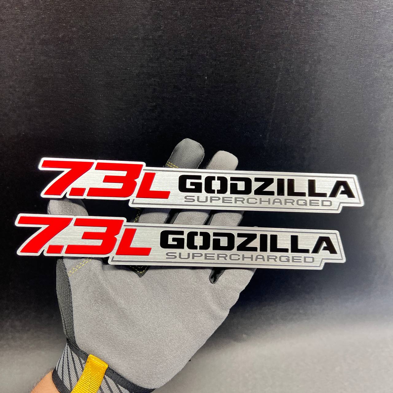 Two matching 7.3L Godzilla Supercharged engine badges for truck exterior