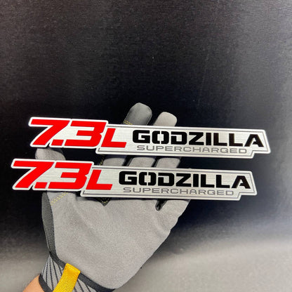 Two matching 7.3L Godzilla Supercharged engine badges for truck exterior