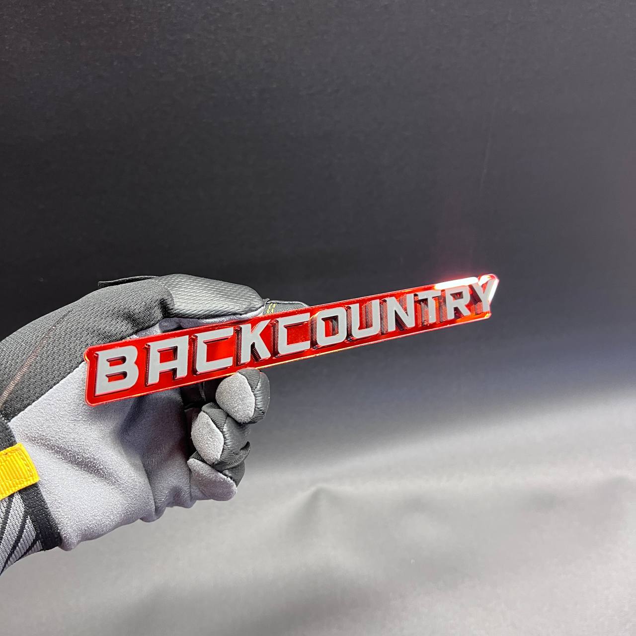 Back Country car emblem with glossy red and silver layered design