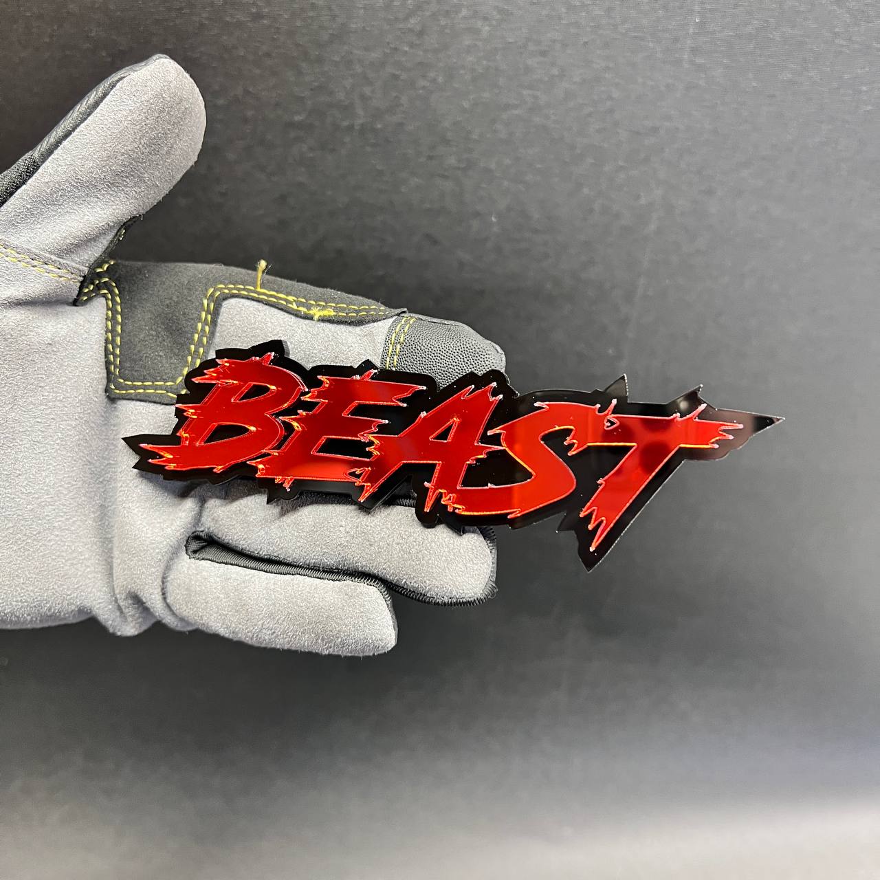Red BEAST custom exterior badge displayed against a black acrylic base