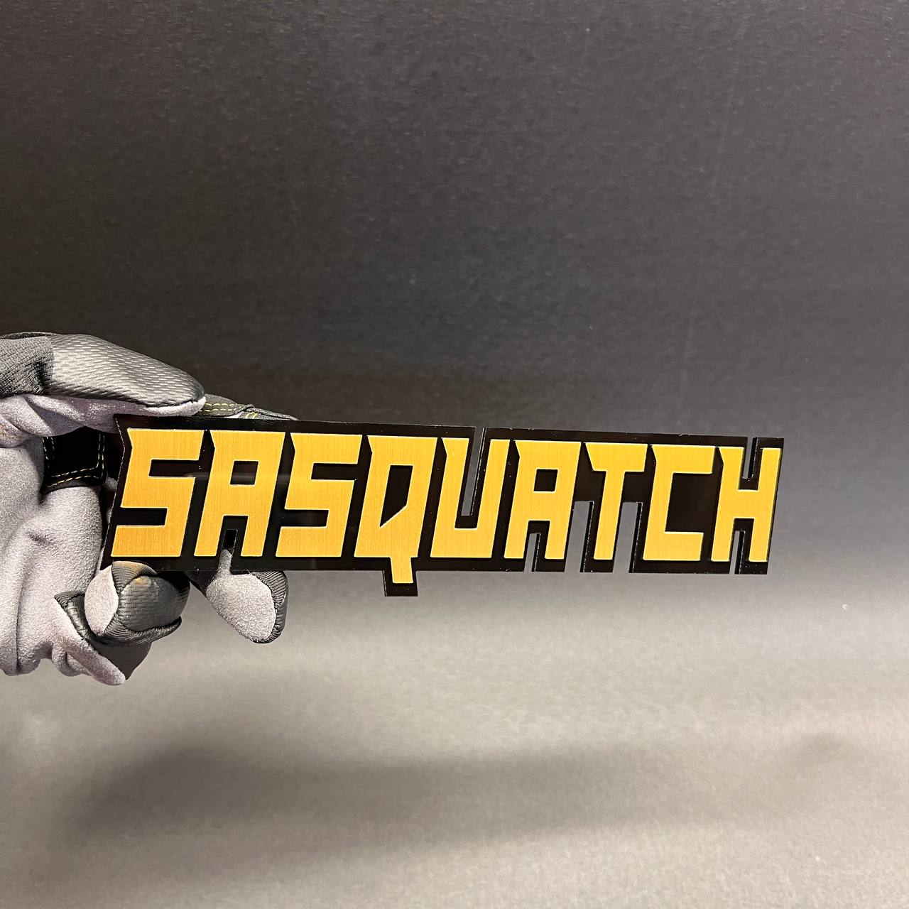 Bigfoot inspired vehicle emblem with black base and yellow top layer