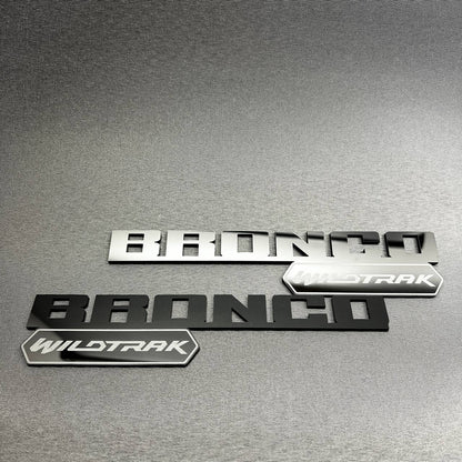 Black Bronco Wildtrak badge with layered lettering and trim emblem