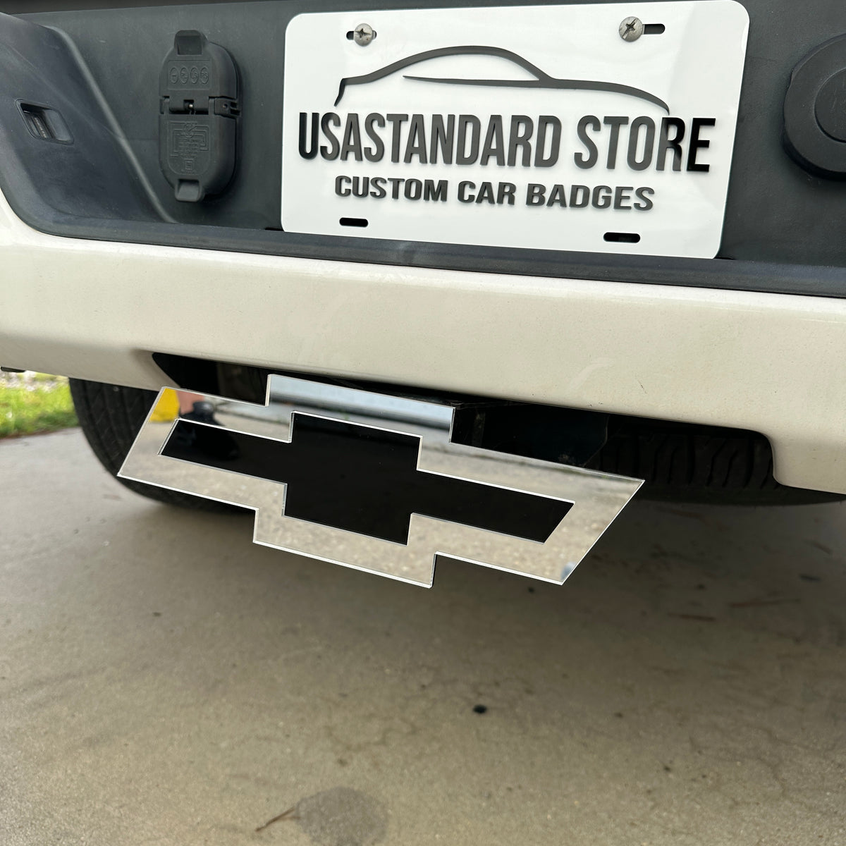 Chevrolet receiver hitch cover with silver border and black Bowtie center
