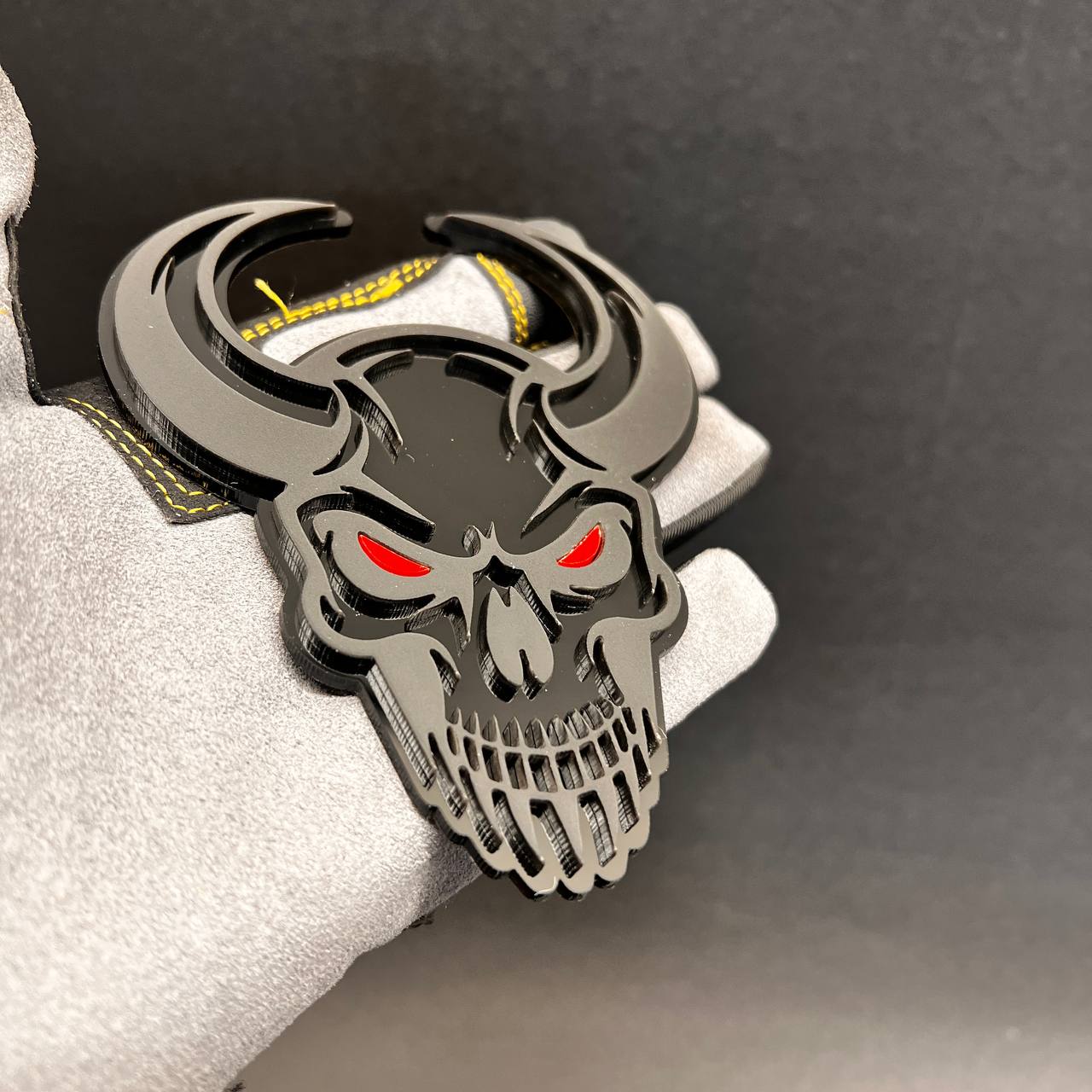 Black and gray Demon Skull car emblem with red eye details