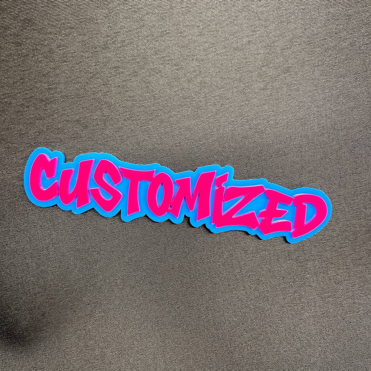 Custom graffiti badge with pink lettering and blue background for car emblem