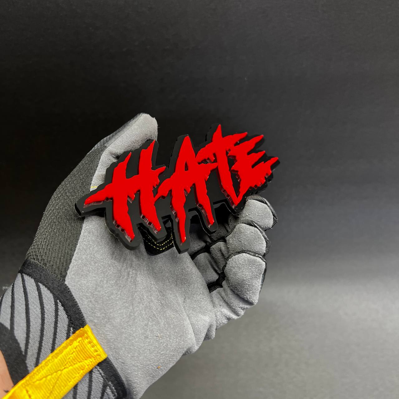 Custom red HATE acrylic emblem on black base with bold edgy design.