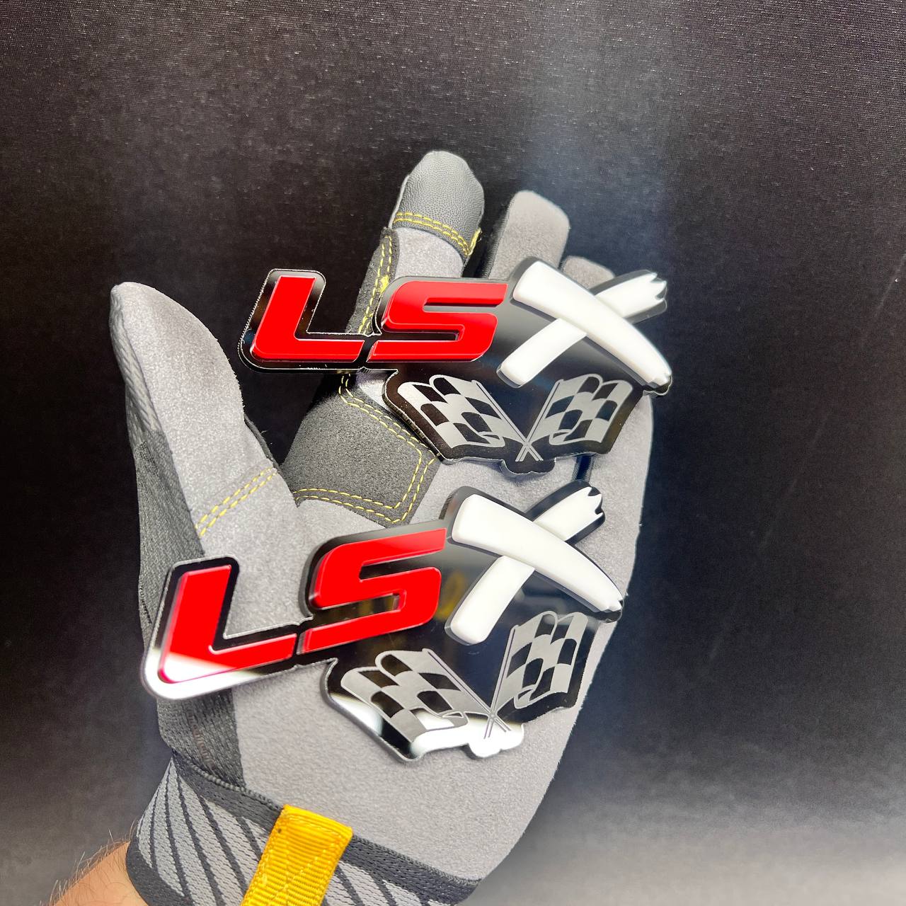 Layered LSX performance car badge displayed in red, white, and glossy black