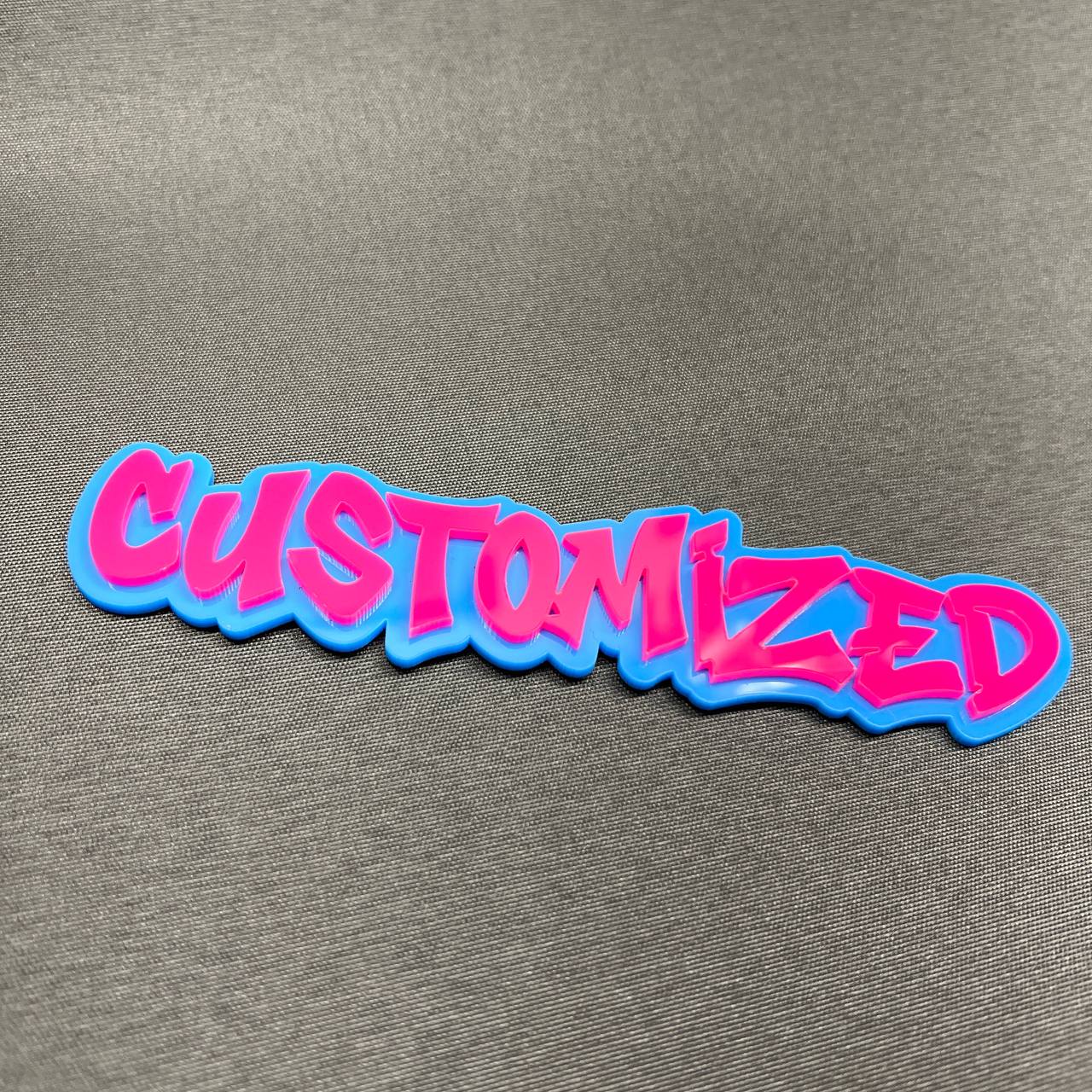 Pink and blue customized car emblem with graffiti style text