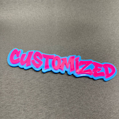 Pink and blue customized car emblem with graffiti style text