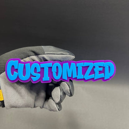 Custom graffiti text car badge with blue letters and purple backing