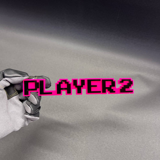 PLAYER 2 car badge in pink and black pixel style for vehicle exterior.