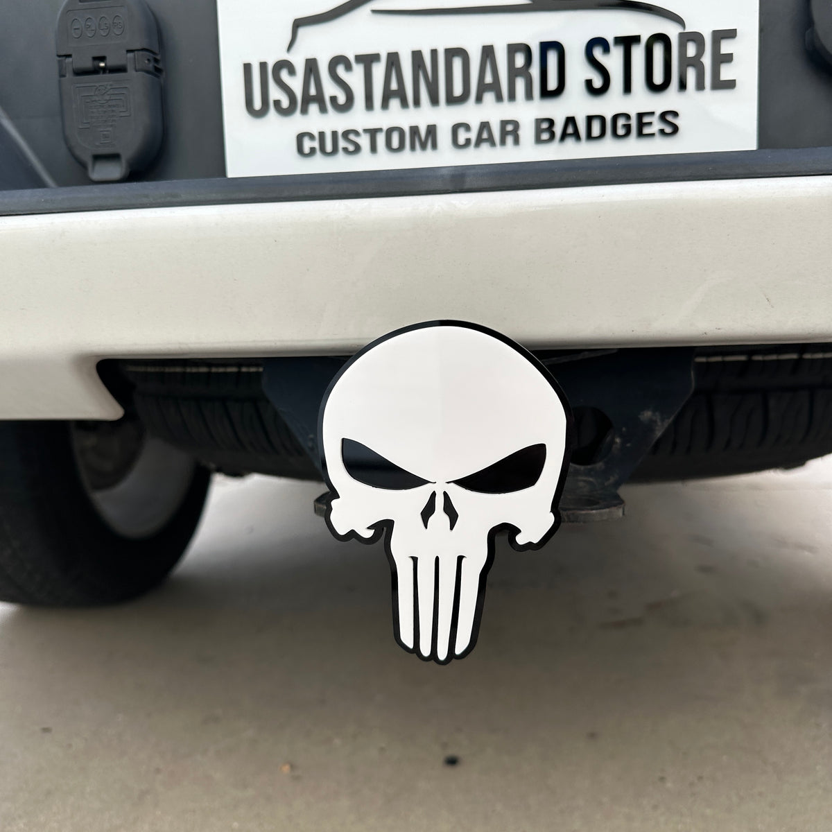 White and black Punisher skull hitch cover emblem mounted on truck receiver