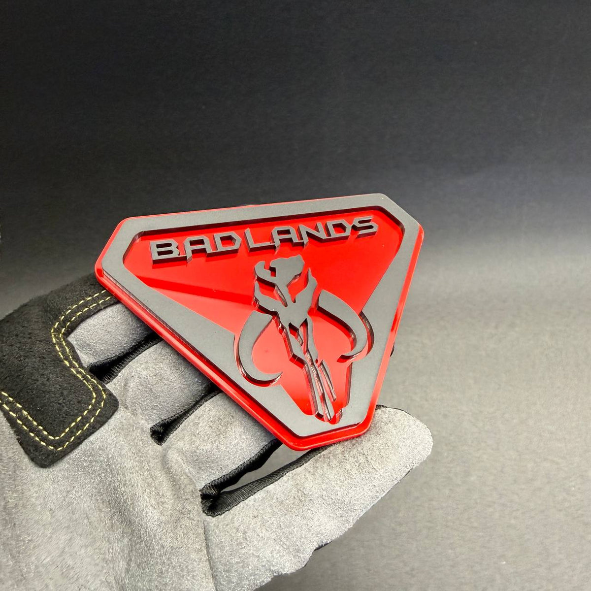 Custom Badlands Mythosaur fender emblem in red and black, designed for personalized Ford Bronco, Jeep Wrangler and off-road truck accessories.
