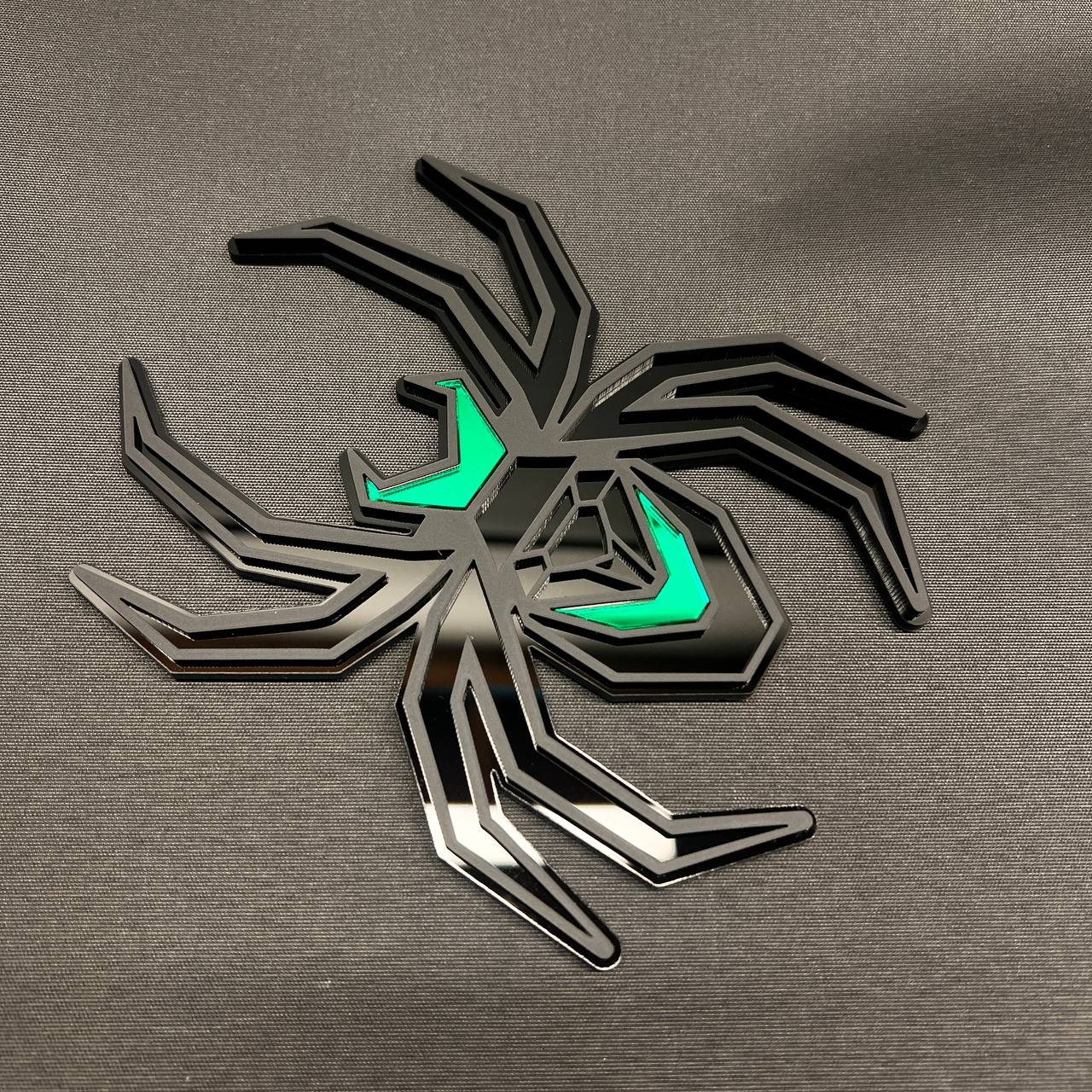 Custom matte black Black Widow truck hitch cover with contrasting green body accents.