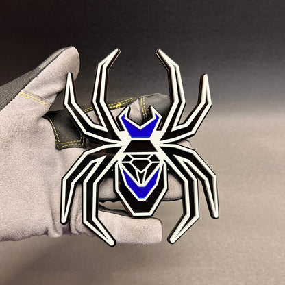 Black Widow fender badge with gray outline, black base, and bright mirror blue body accents.