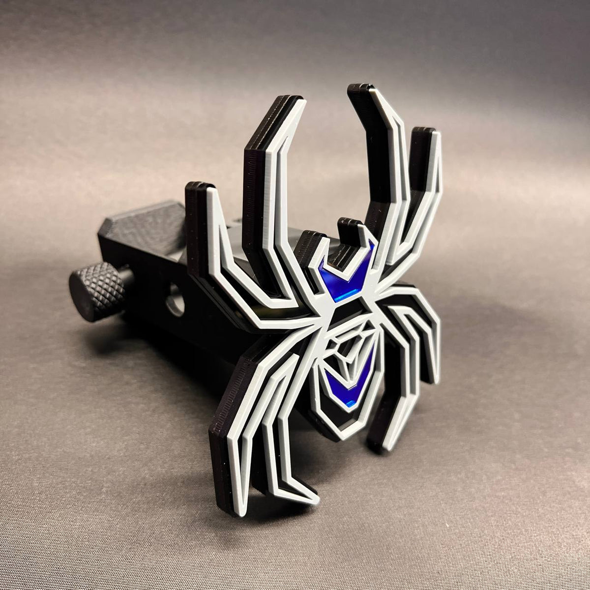 Black Widow automotive hitch cover featuring black base, gray outline, and mirror blue details.