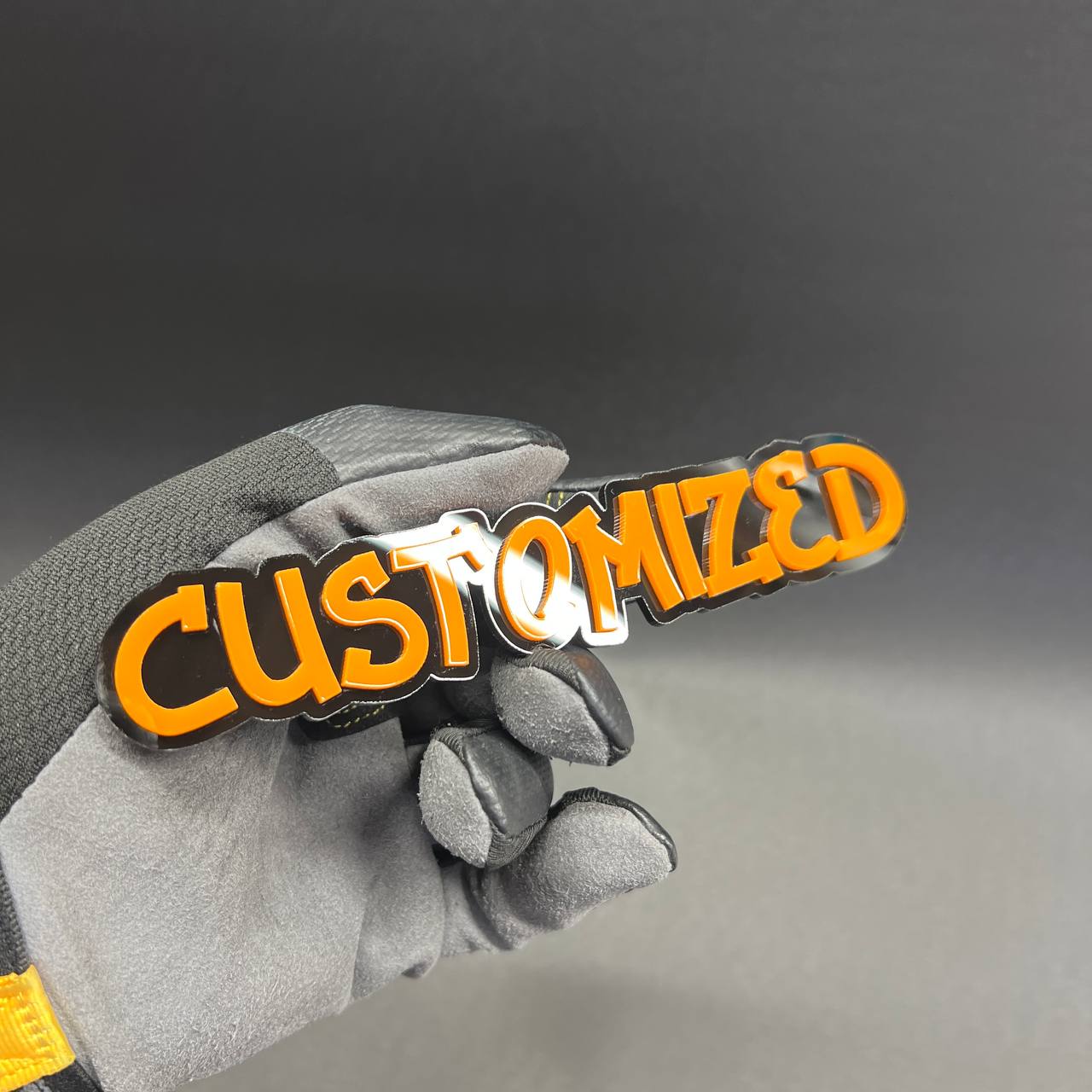 Custom made graffiti text vehicle badge with orange letters.