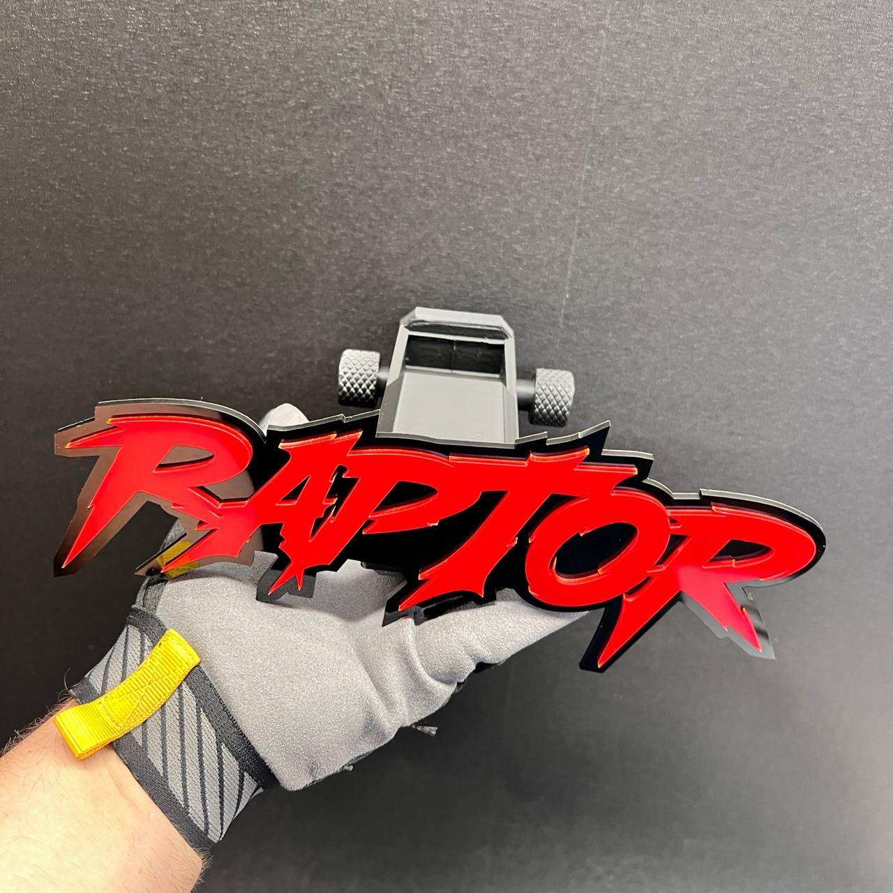 Custom text car hitch cover featuring a red RAPTOR emblem