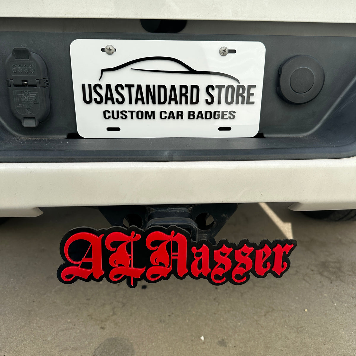 Custom word hitch cover with red lettering and black base for rear truck receiver