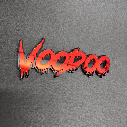 Red mirror VOODOO vehicle badge with a layered black base