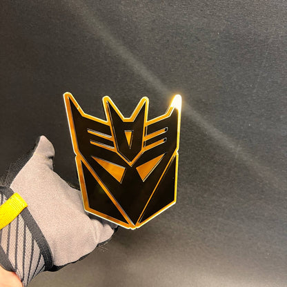 Black and gold Decepticon hitch receiver cover for truck exterior accessory.