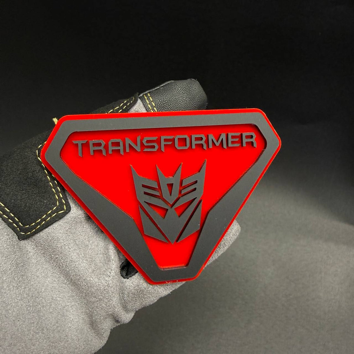 Transformer Decepticon Badlands shield emblem for Ford Bronco Badlands with bold TRANSFORMER lettering and silver robot insignia.