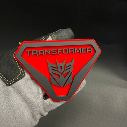 Transformer Decepticon Badlands shield emblem for Ford Bronco Badlands with bold TRANSFORMER lettering and silver robot insignia.