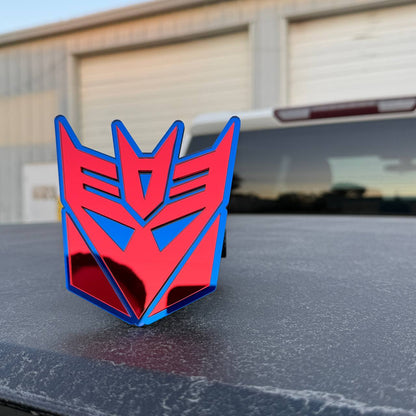 Red mirror and blue Transformers Decepticon emblem hitch cover for Dodge Ram 1500 pickup.