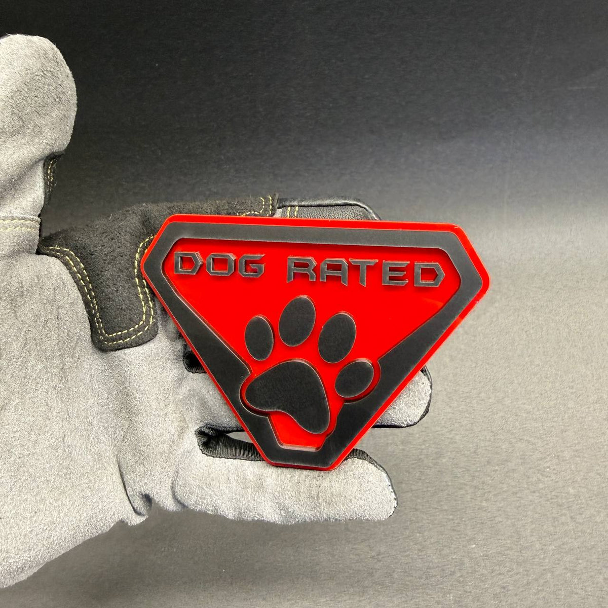 Red and black Dog Rated custom car badge with layered paw print design for Toyota Tacoma, Tundra, 4Runner and other outdoor adventure vehicles.