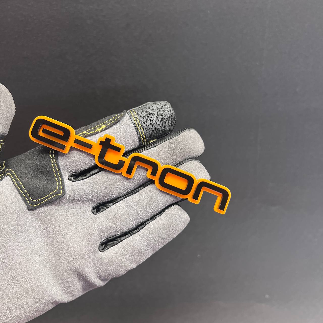 Custom E-TRON vehicle badge with layered orange and black design