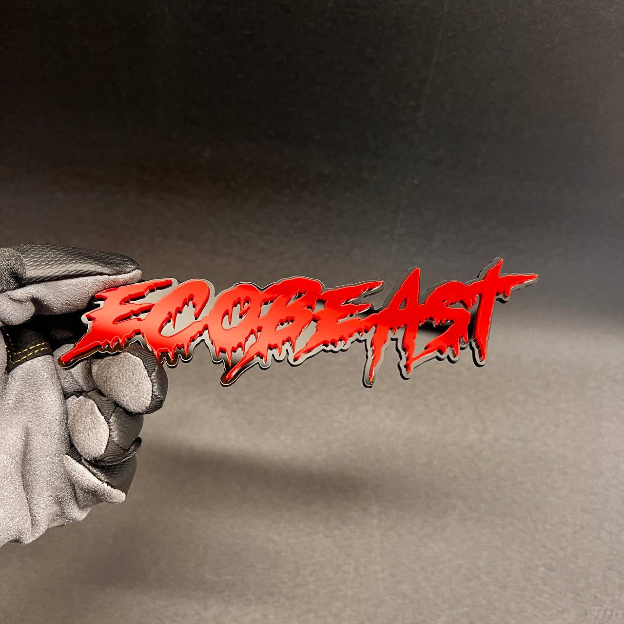 Custom ECOBEAST car badge with red lettering and black base for fender or tailgate