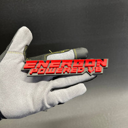 Custom ENERGON Powered V8 red and black acrylic text badge with raised lettering.