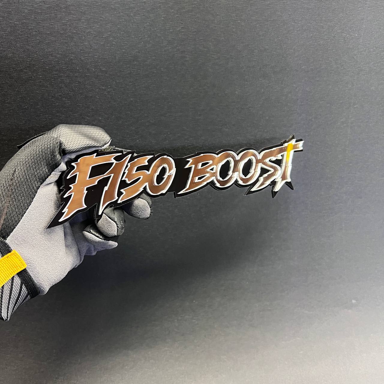 F 150 Boost fender badge with aggressive performance inspired lettering and layered finish.