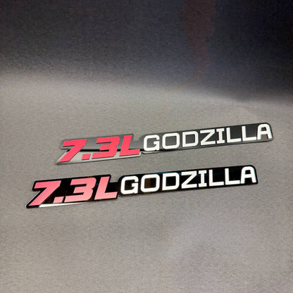 Ford F350 7.3 liter Godzilla V8 aftermarket engine badge featuring red 7.3L lettering and white Godzilla design.