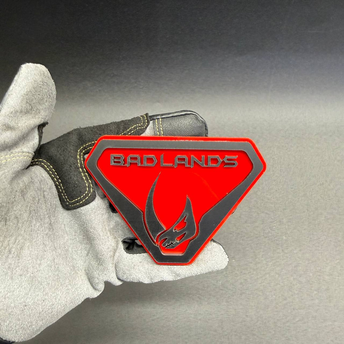 . Custom Ford Bronco Badlands Mudhorn fender emblem featuring layered red and black design for personalized off-road SUV exterior decoration.