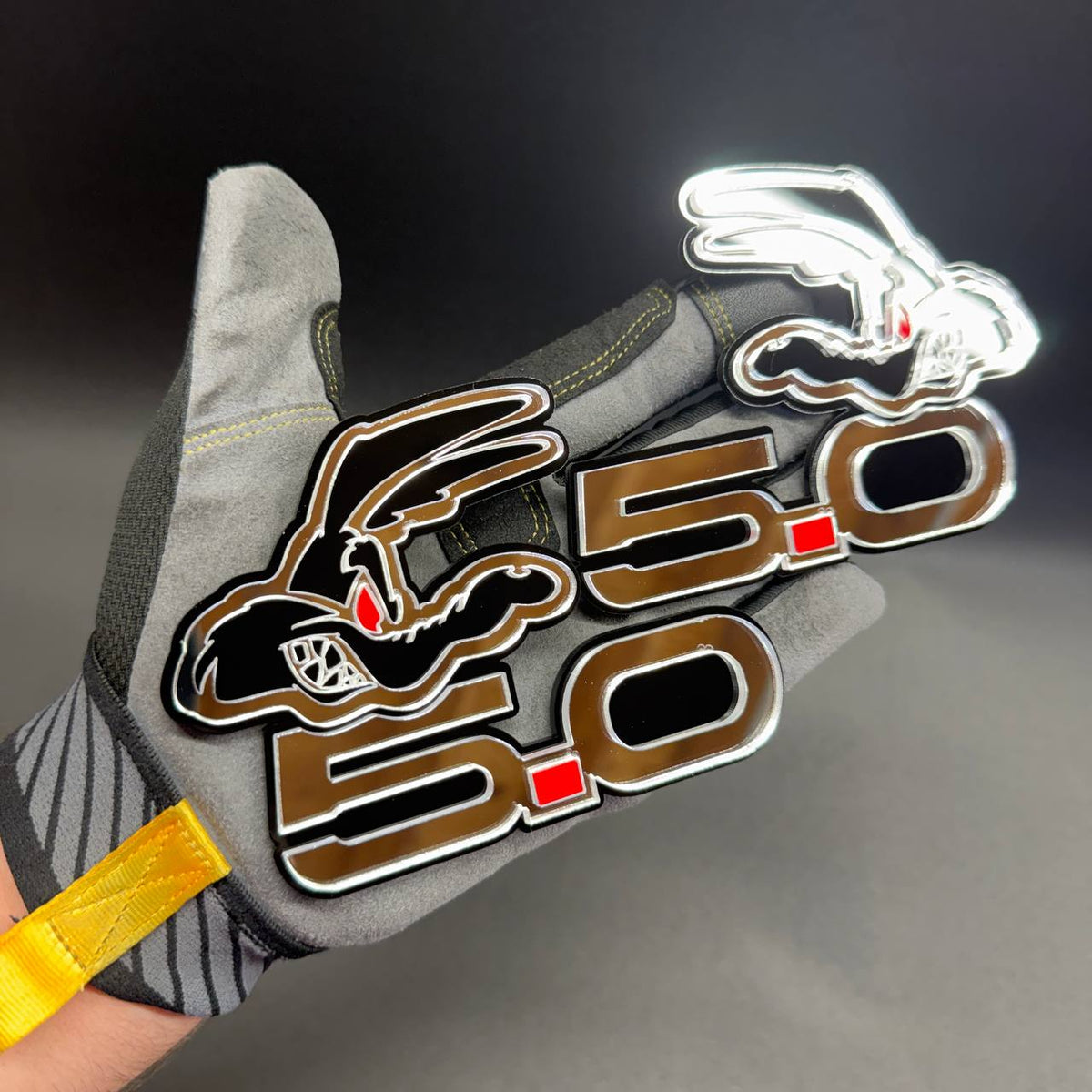 Mustang 5.0 Coyote engine badge with aggressive coyote face and metallic reflective silver accents for automotive customization.