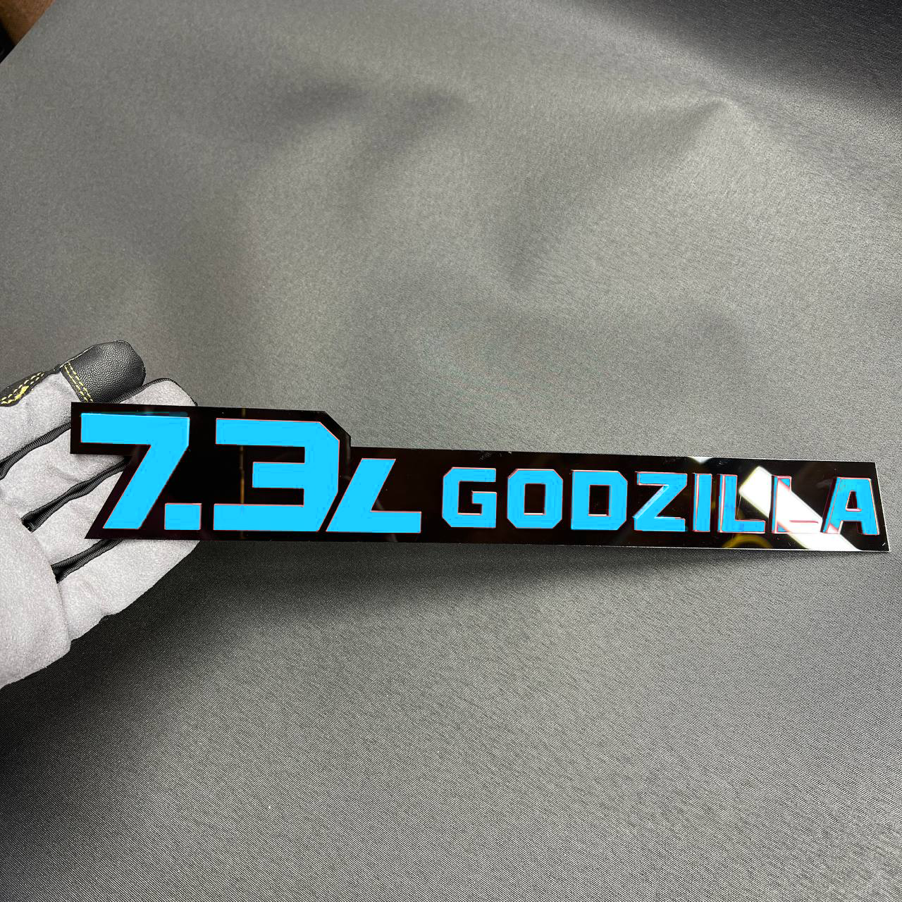 7.3L Godzilla engine emblem with bold pink lettering for Ford truck accessory styling.
