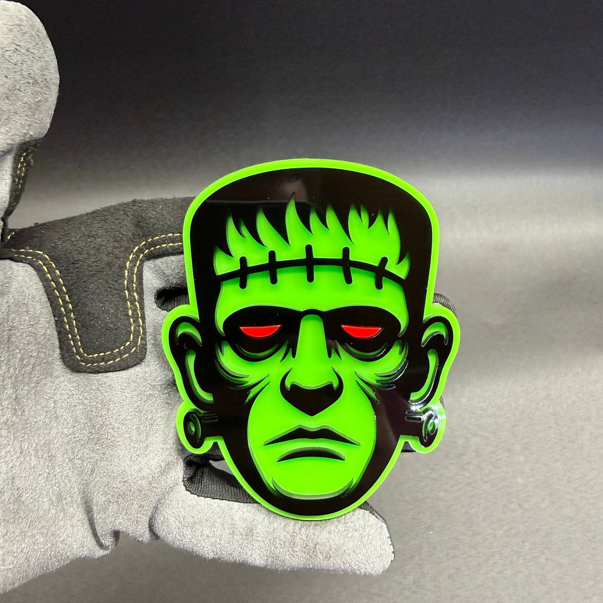 Green Frankenstein monster car badge Halloween fender emblem with black face details and red eyes