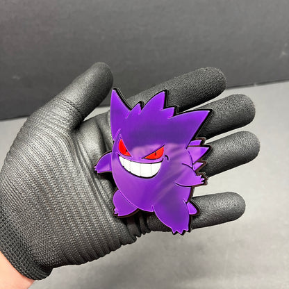 Close up of Gengar style car badge held in hand