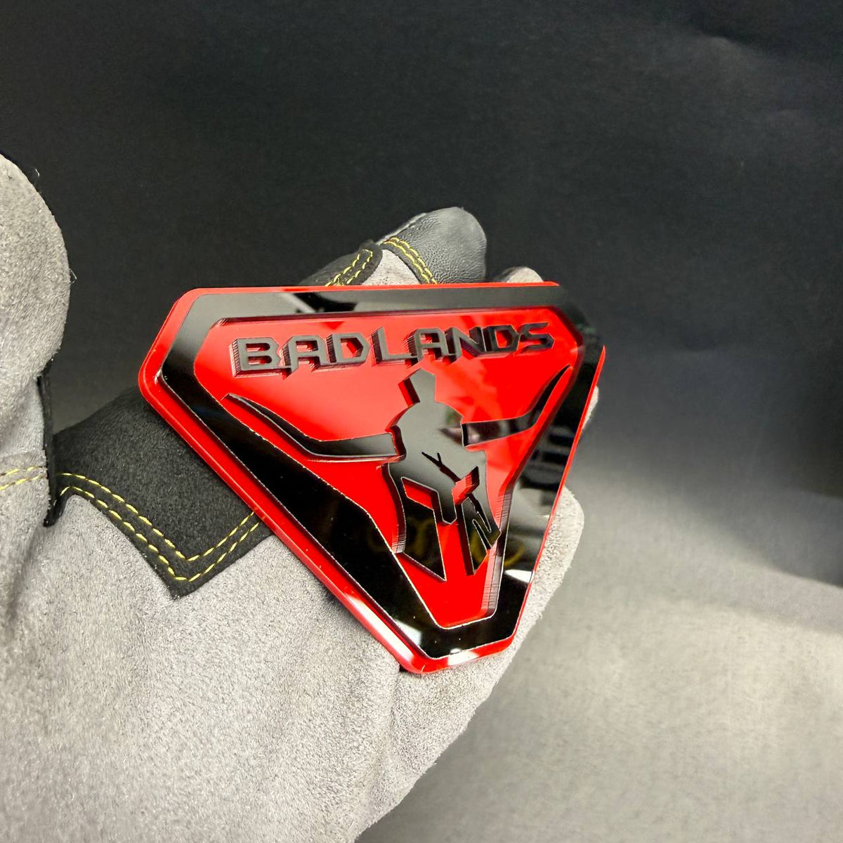 Badlands Gladiator fender badge featuring black and red warrior helmet automotive emblem.