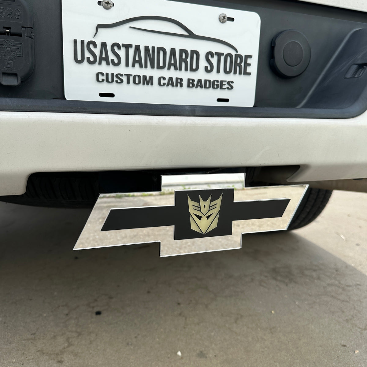 Chevy truck hitch cover with silver emblem and Decepticon badge insert