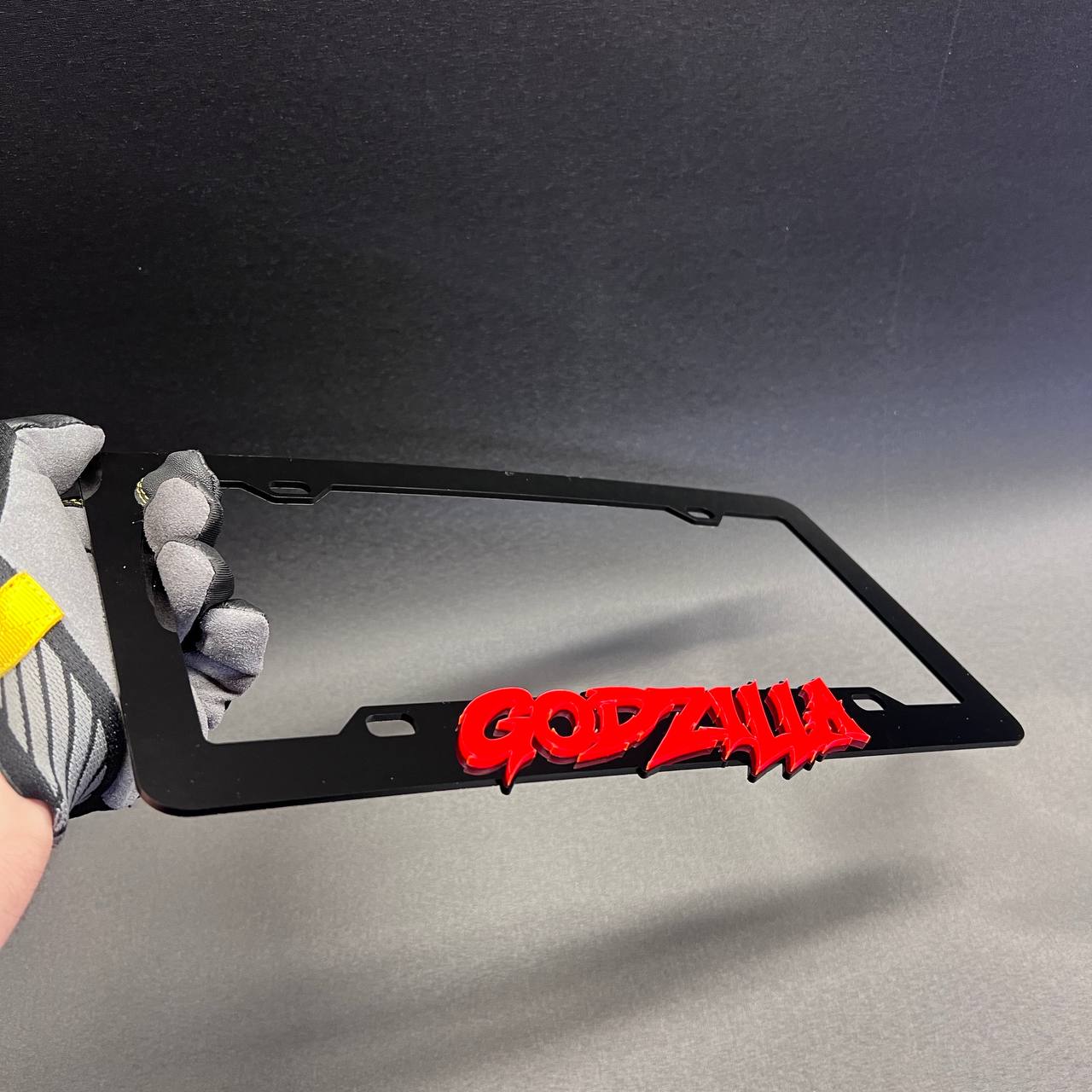 Black and red Godzilla inspired car frame with bold 3D text design