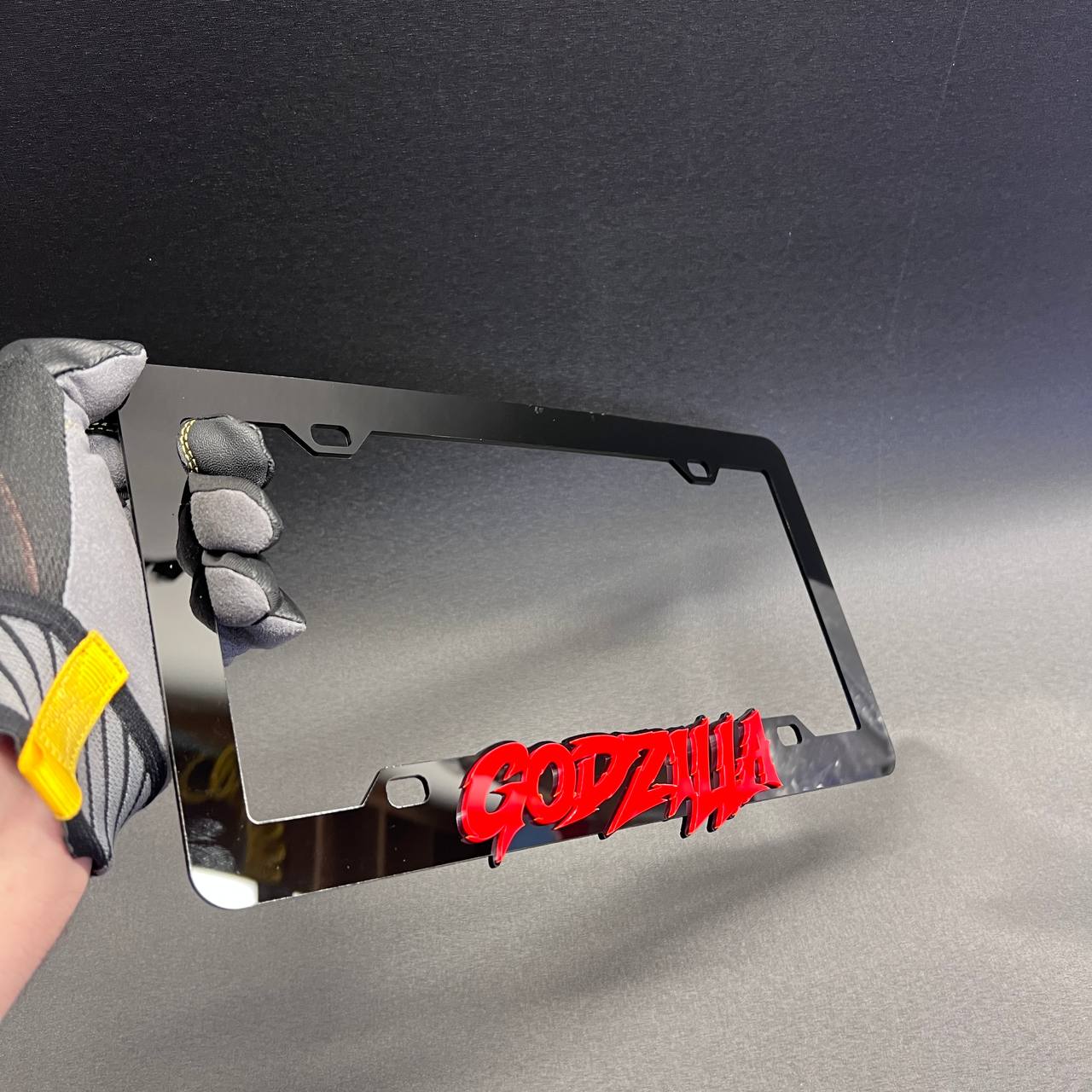Red and black Godzilla car accessory frame for exterior license plate area